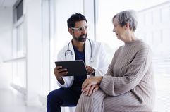 Doctor and patient in conversation, looking at digital tablet