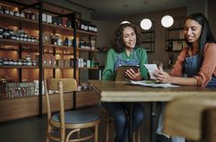 Two workers at a small business go over receipts