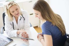  Doctor talking to patient in office