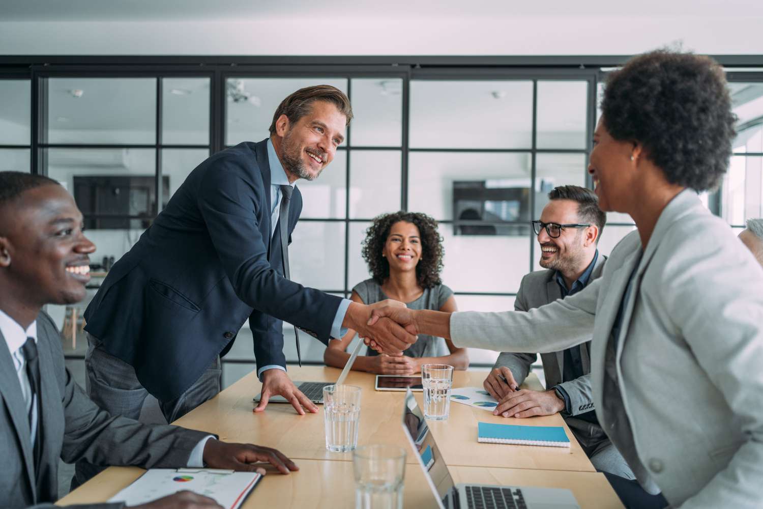 People shaking hands in a business meeting in a conference room