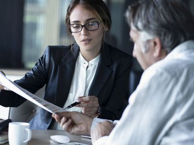 Two people looking at paperwork in a meeting