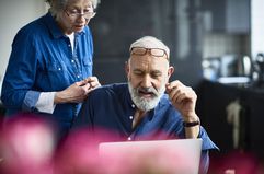 Hipster Senior Man With Beard Using Laptop and Woman Watching