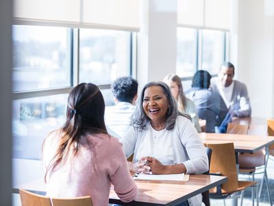 Senior woman smiles while meeting with financial advisor