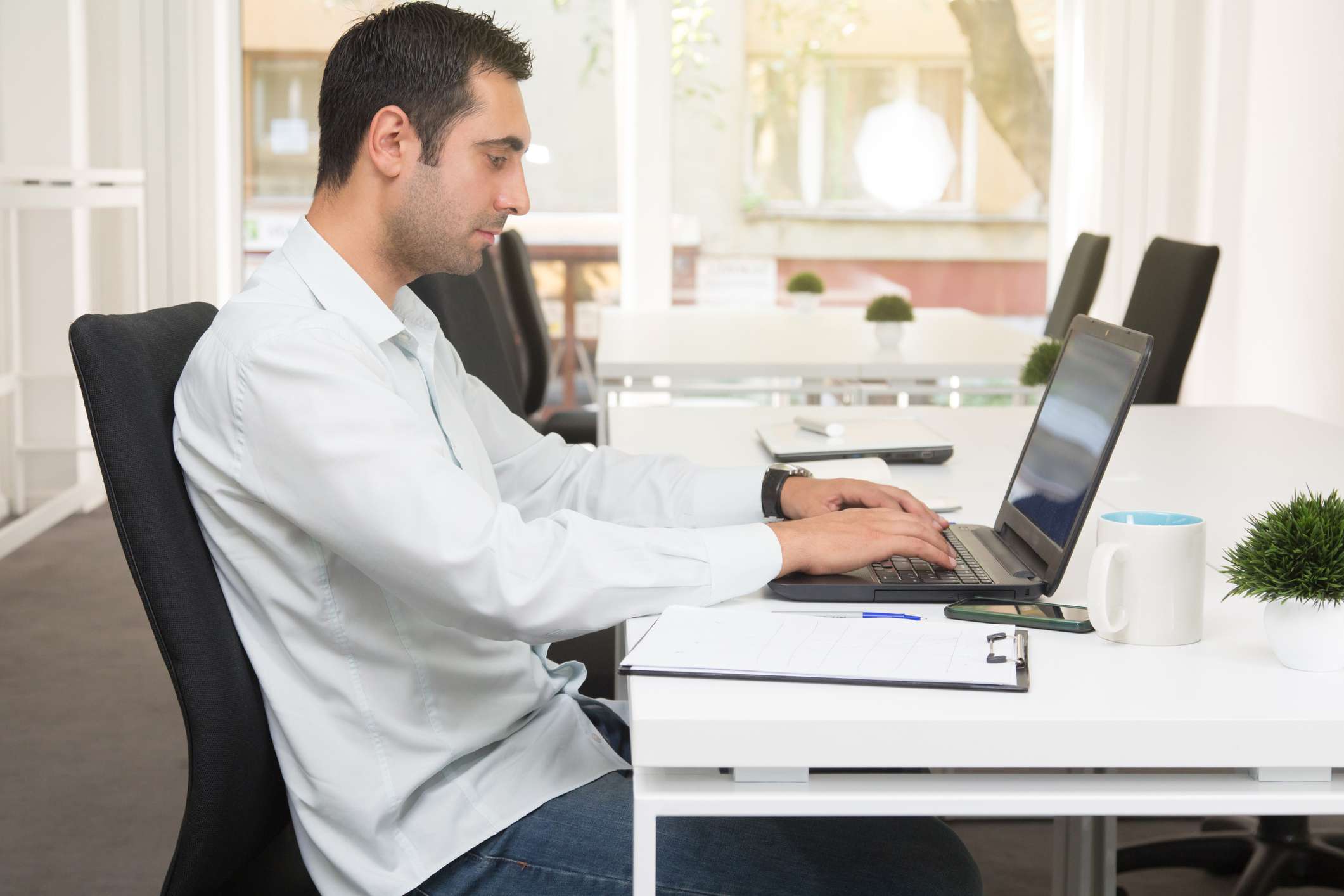 A young man using laptop at the business office.