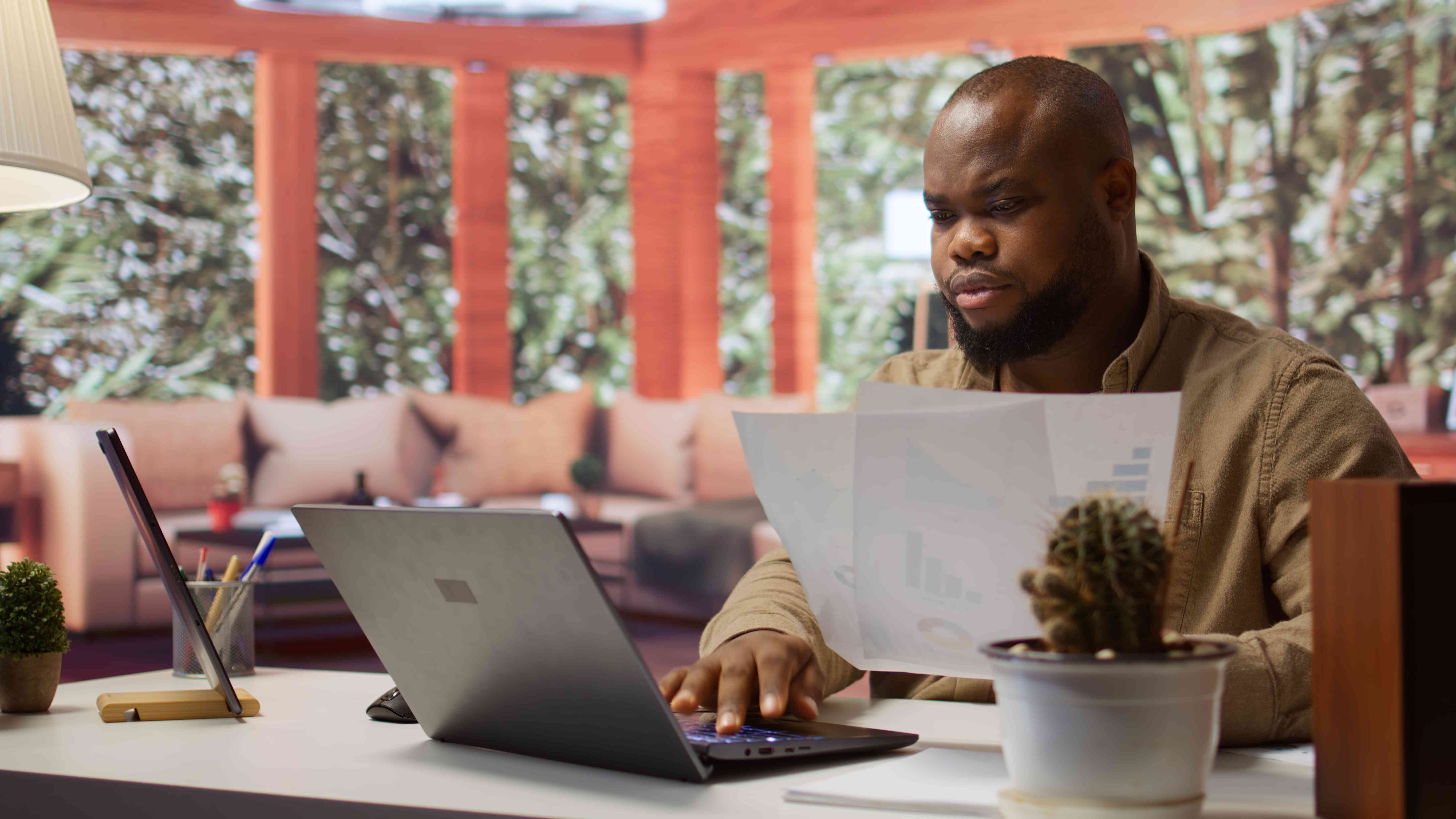 Man at desk with papers and laptop