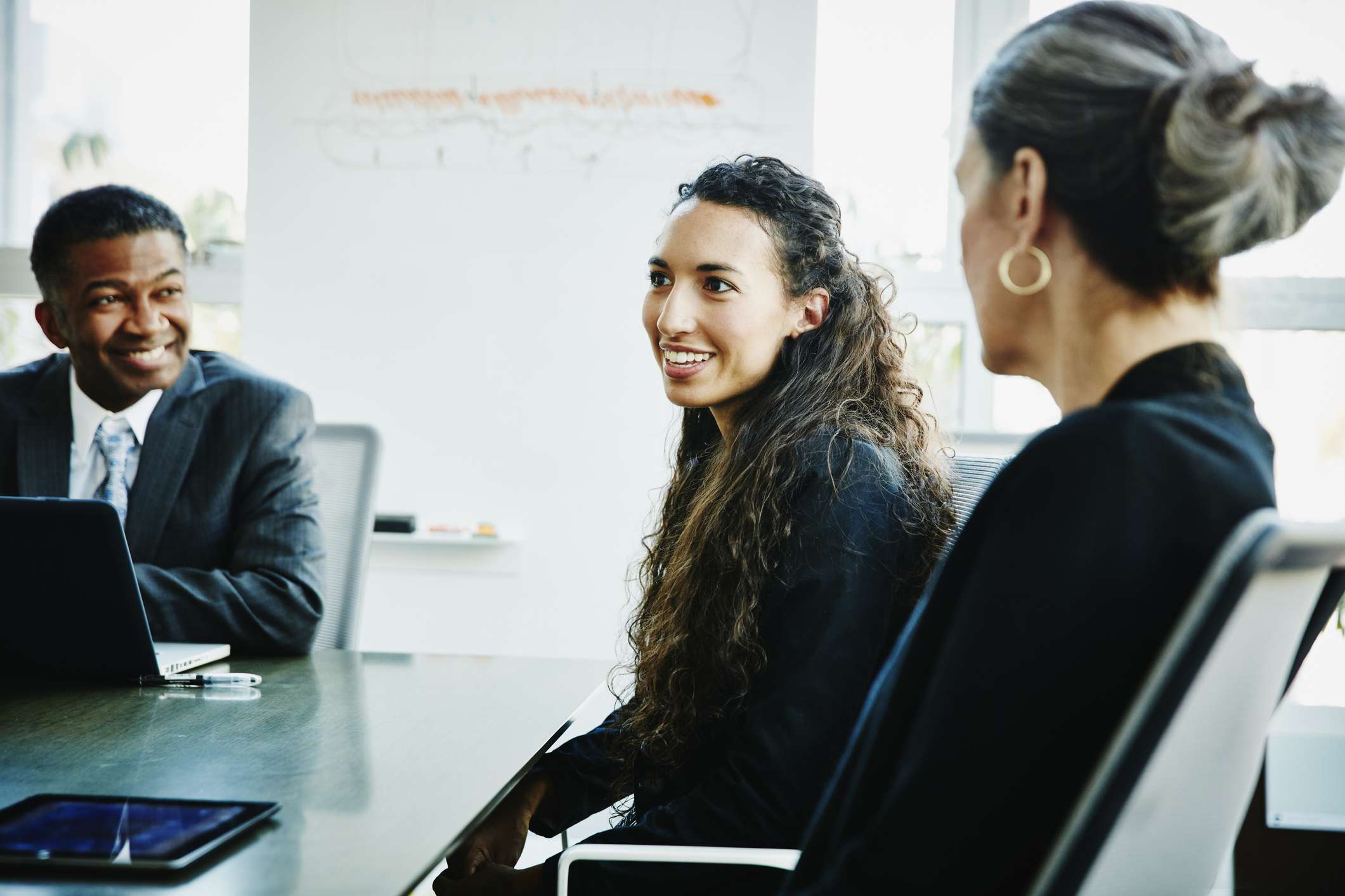 A businesswoman leading discussion during meeting in office conference room.