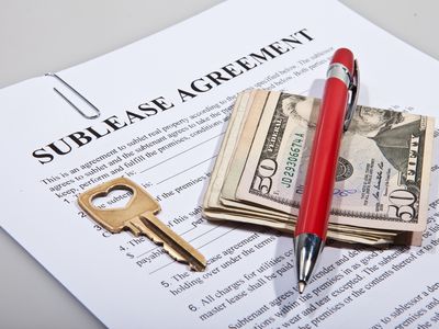 A sublease legal agreement with a key, pen and folded money