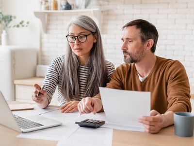 Middle-aged couple reviewing finances on computer at home