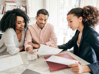 Couple talks to a businesswoman about getting tuition insurance for their child