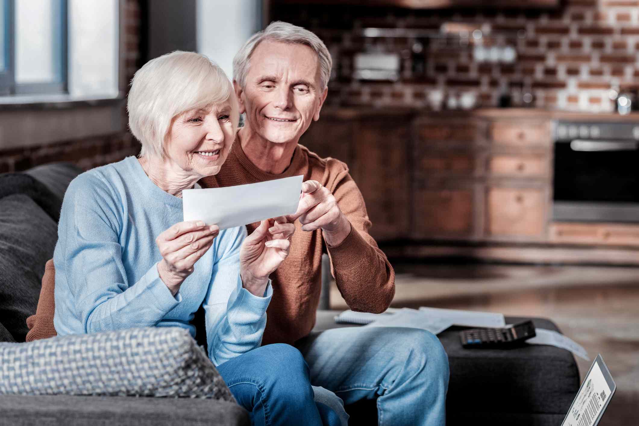 A couple sitting on the sofa and watching at counting.