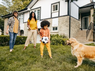 Shot of family playing soccer together with their dog.