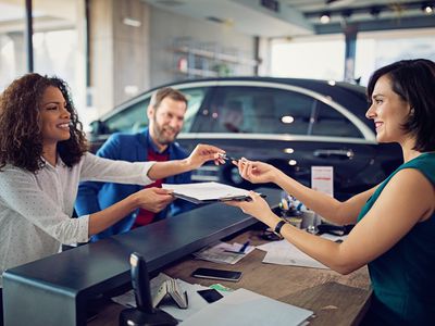 Couple is leasing new car and signing the contract