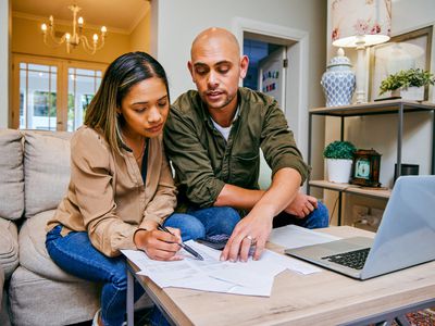 A couple reviews paperwork in their home.