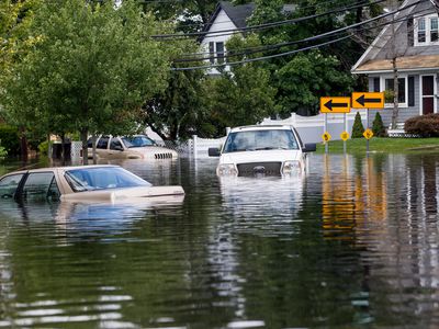 A flooded street with cars standing in deep water.