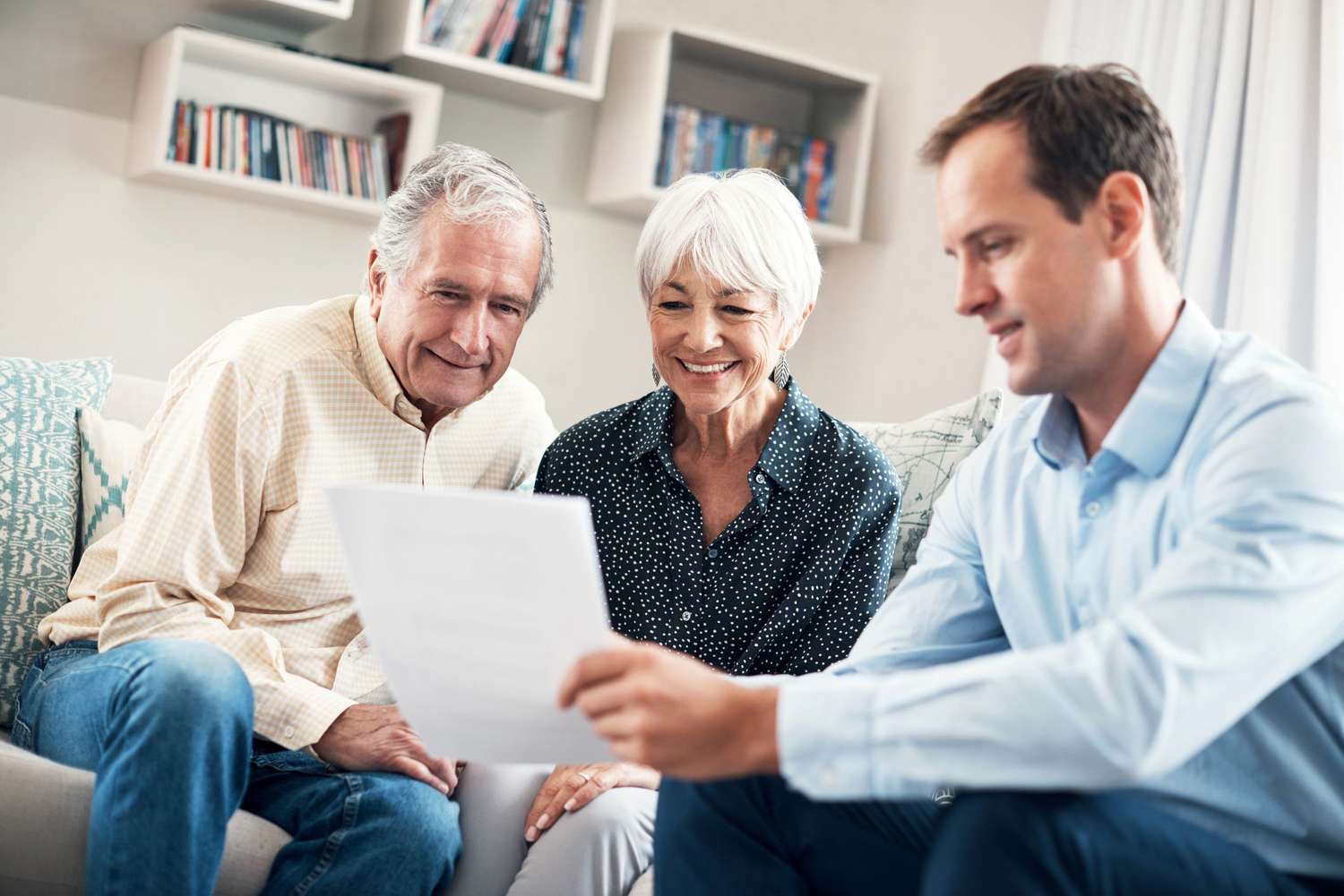 A man showing an older couple some papers