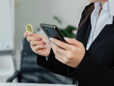 Person holding a coin and looking at phone