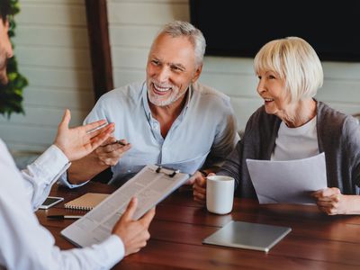 Happy elderly couple talking with an advisor