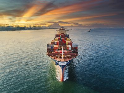 Aerial front view of cargo ship in the water carrying containers