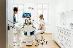 Dentist looking At X-Ray With Patient