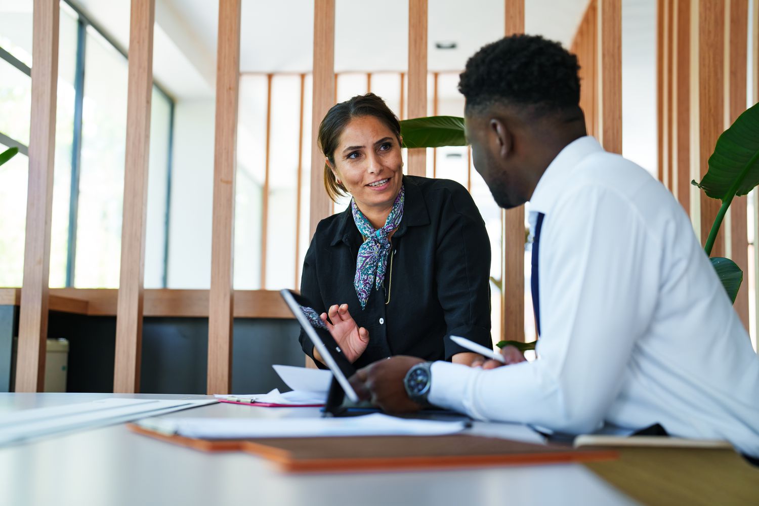 Two lenders discussing whether a prospective borrower qualifies for no-appraisal refinancing