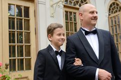 Portrait of father and young son smiling in tuxedos