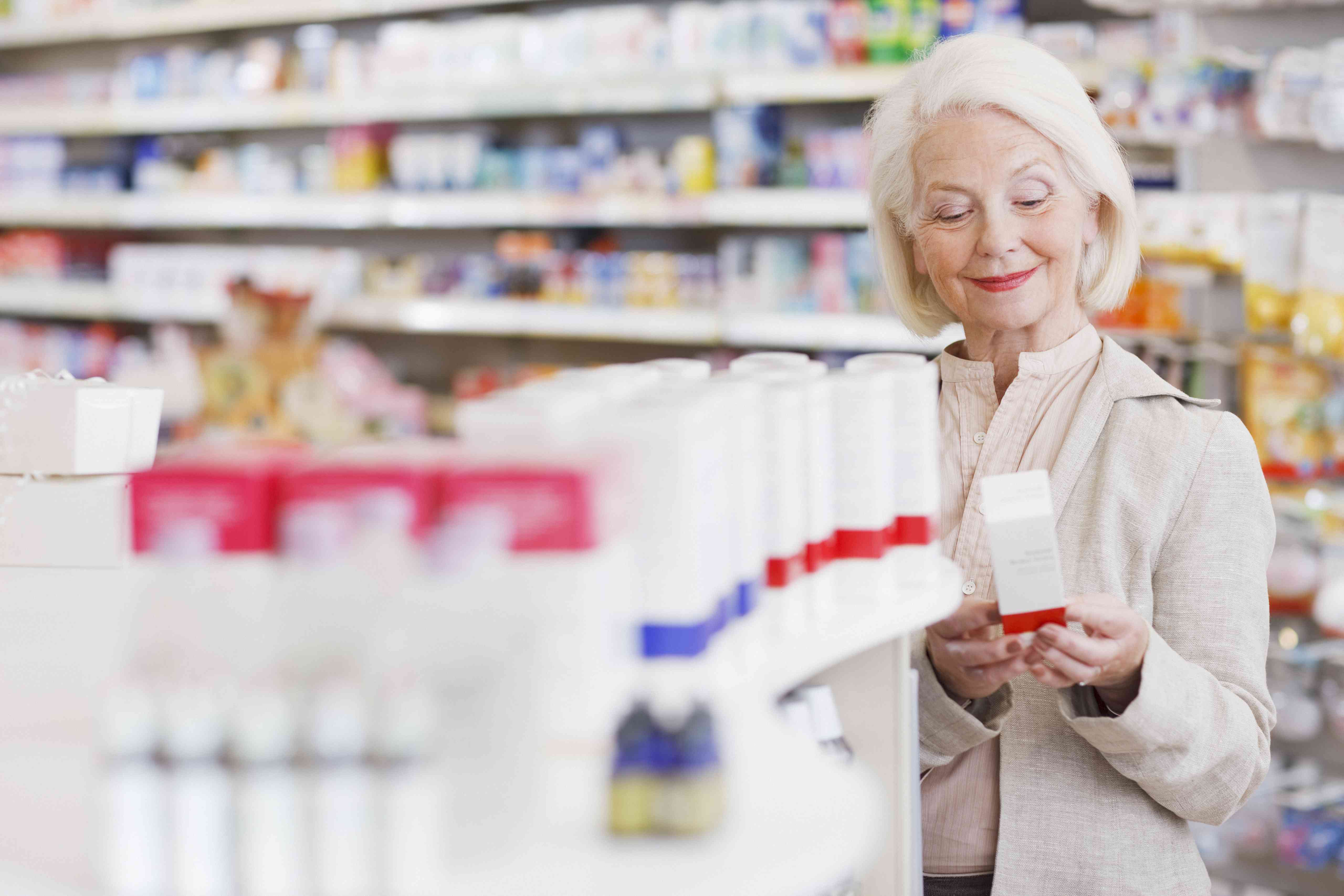 Senior woman reading product packaging in drug store