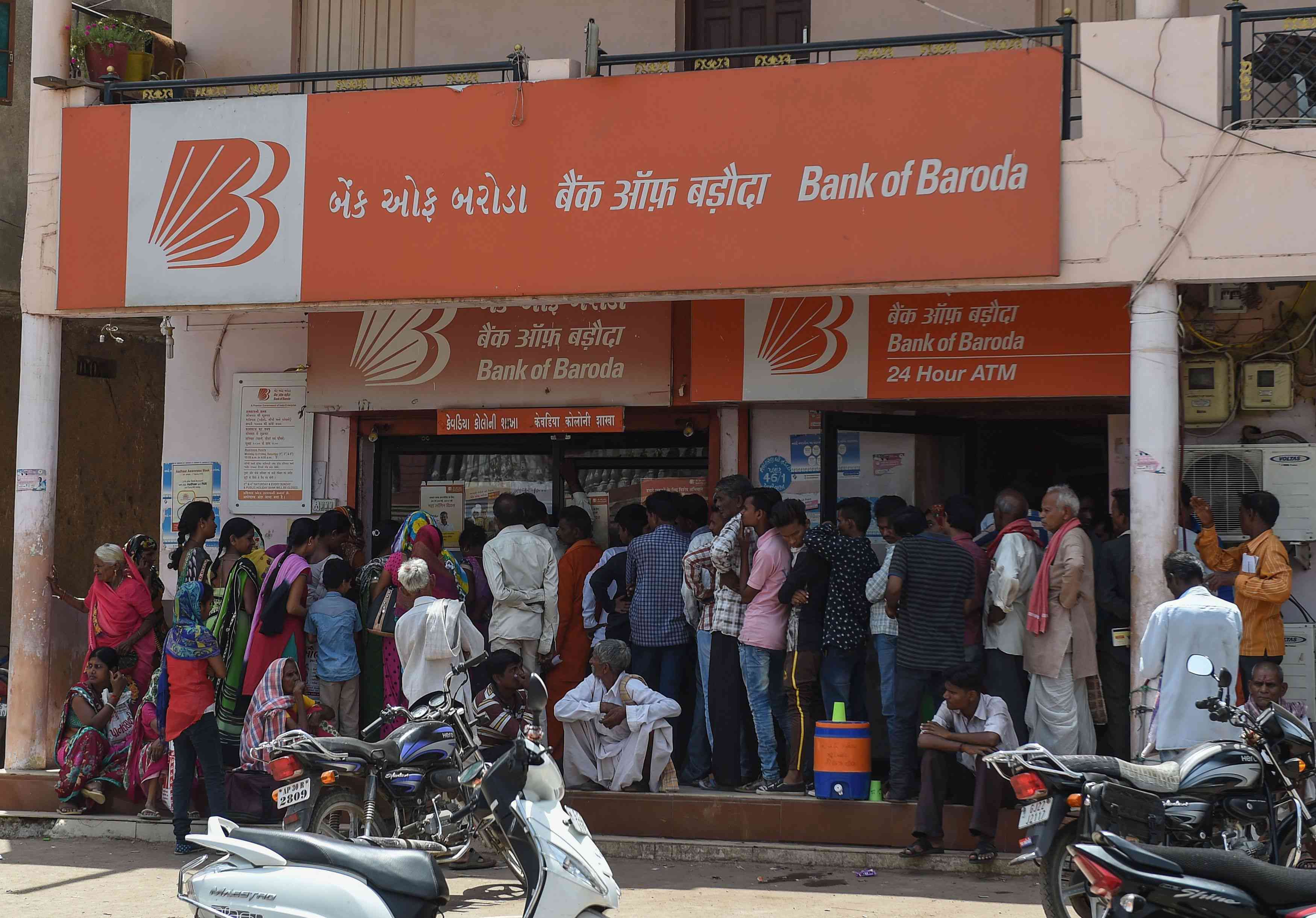 People queue outside of a branch of the Bank Of Baroda in Kevadiya Colony, on the outskirts of Rajpipla in India's western Gujarat state.