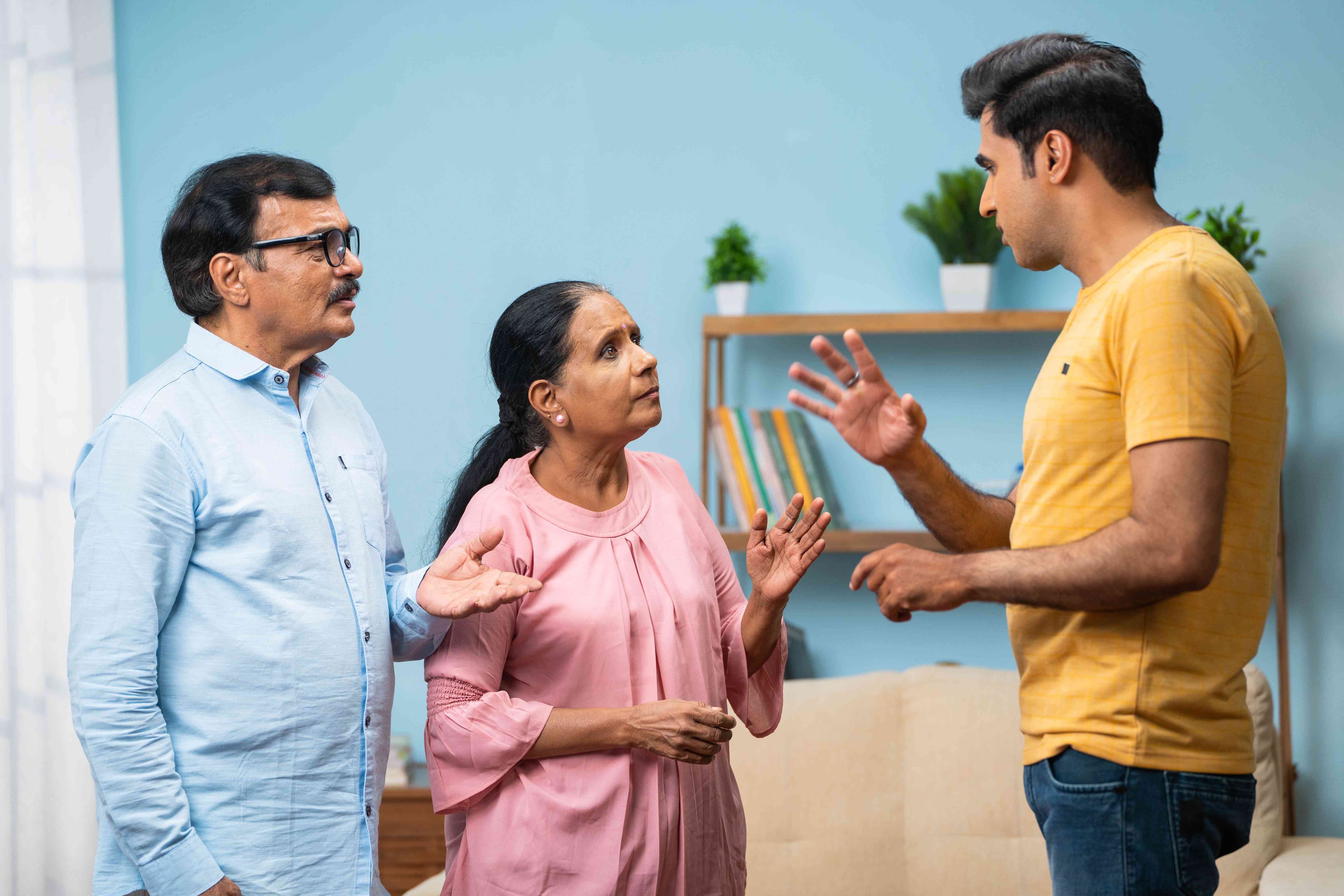 A young adult argues with their parents trying to force them to sign a loan document.