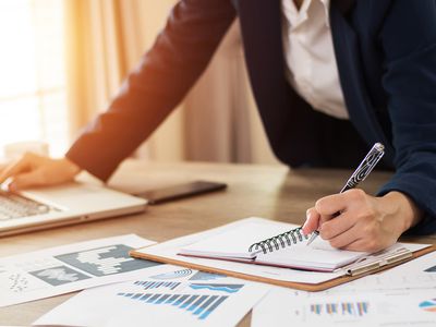 Hands of Financial Manager Taking Notes When Working