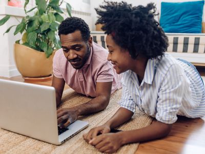 A young couple reviews financial options on their laptop