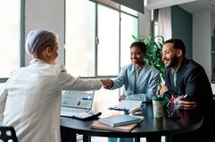 A financial advisor meets with clients in a brightly lit office.