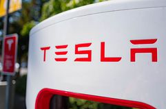 Close up of Tesla logo on a charger at a Supercharger rapid battery charging station for the electric vehicle company Tesla Motors.