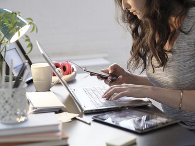 woman researching on computer and phone