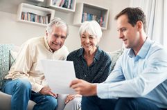 A man showing an older couple some papers