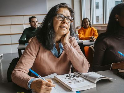 Mature female student sitting with friends in Grad School