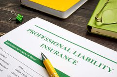 Professional liability insurance and yellow pen for signing