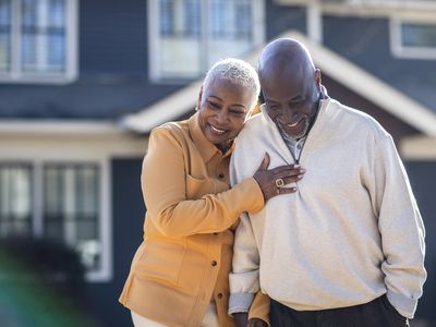 Senior couple couple walking in front of their home