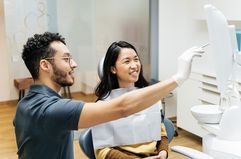 A young woman reviews her check up results with her dentist