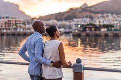 Couple looking out onto water during sunset