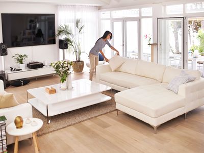 Woman tidying nicely furnished living room