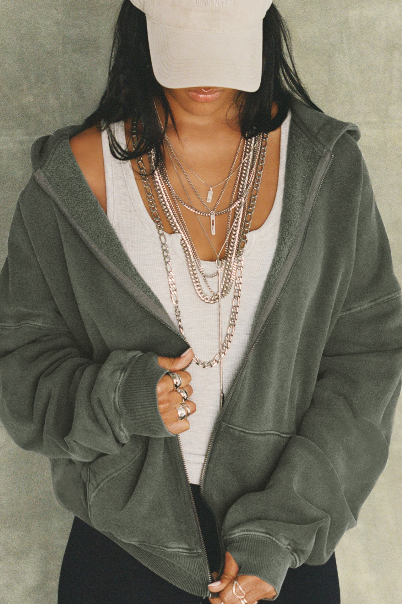 Front view of model posing in the oversized comfortable washed sage french terry Oversized Zip Hoodie with a full length front zip closure, side pockets and thumbholes in the fitted cuffs