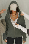 Front view of model posing in the oversized comfortable washed sage french terry Oversized Zip Hoodie with a full length front zip closure, side pockets and thumbholes in the fitted cuffs