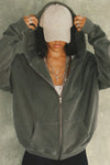 Front view of model posing in the oversized comfortable washed sage french terry Oversized Zip Hoodie with a full length front zip closure, side pockets and thumbholes in the fitted cuffs