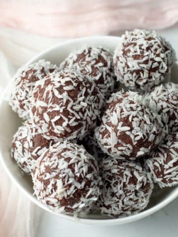 Bowl of chocolate coconut date balls.