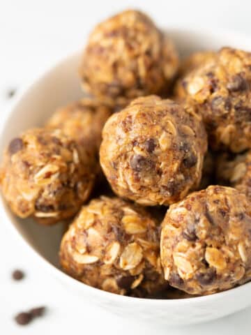 Vegan protein balls with oats and chocolate chips in a white bowl.