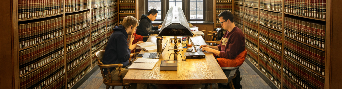 a group of students sitting in a table in a library