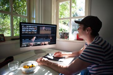 A man editing videos on a Mac computer