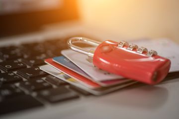 padlock and credit cards sitting on a keyboard, depicting computer security