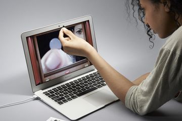 A person covering a laptop webcam