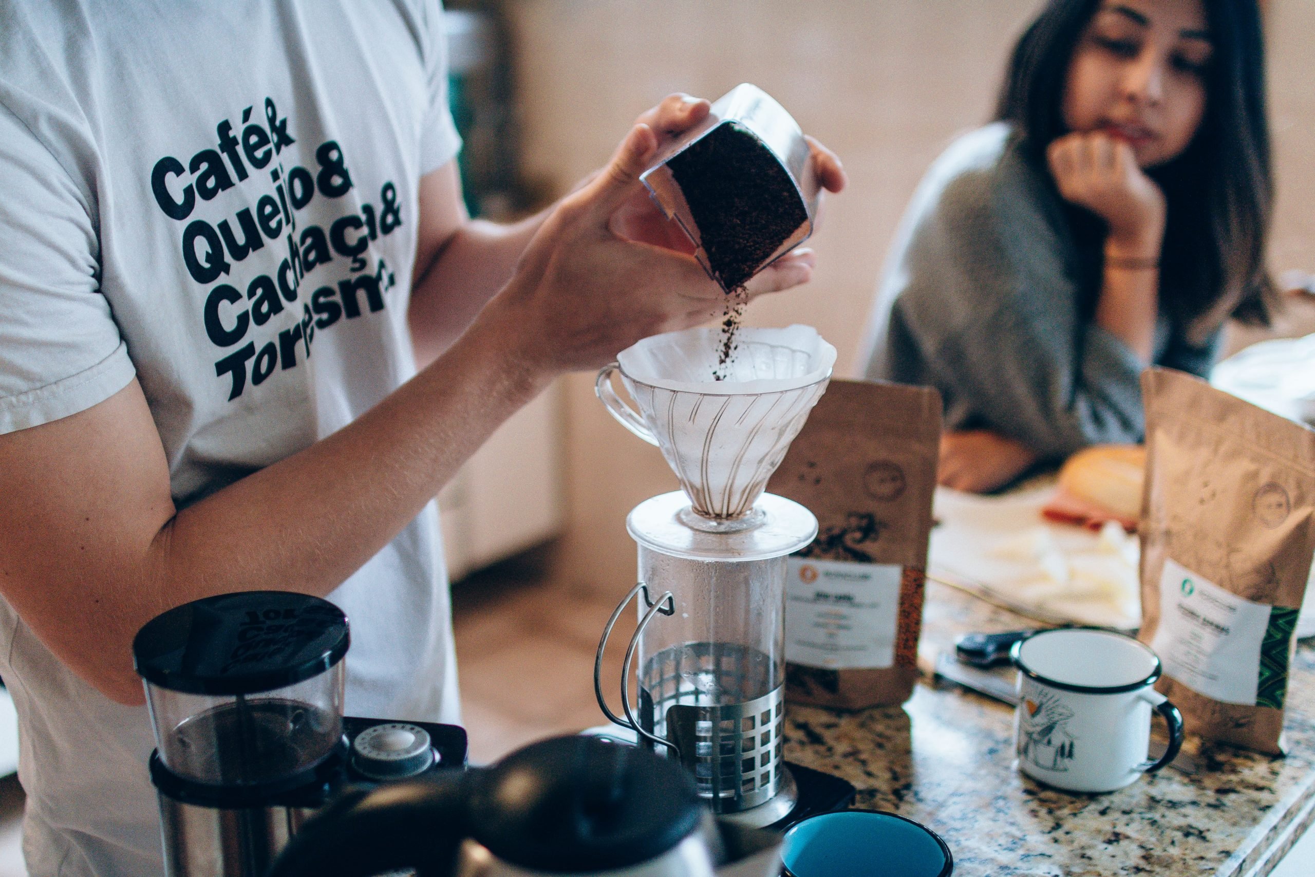 Homem preparando um café cremoso com leite chocolate em pó.